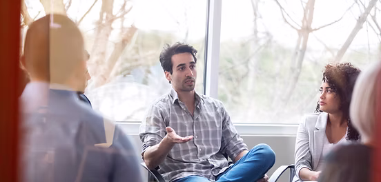 Image of a seated man talking in a group