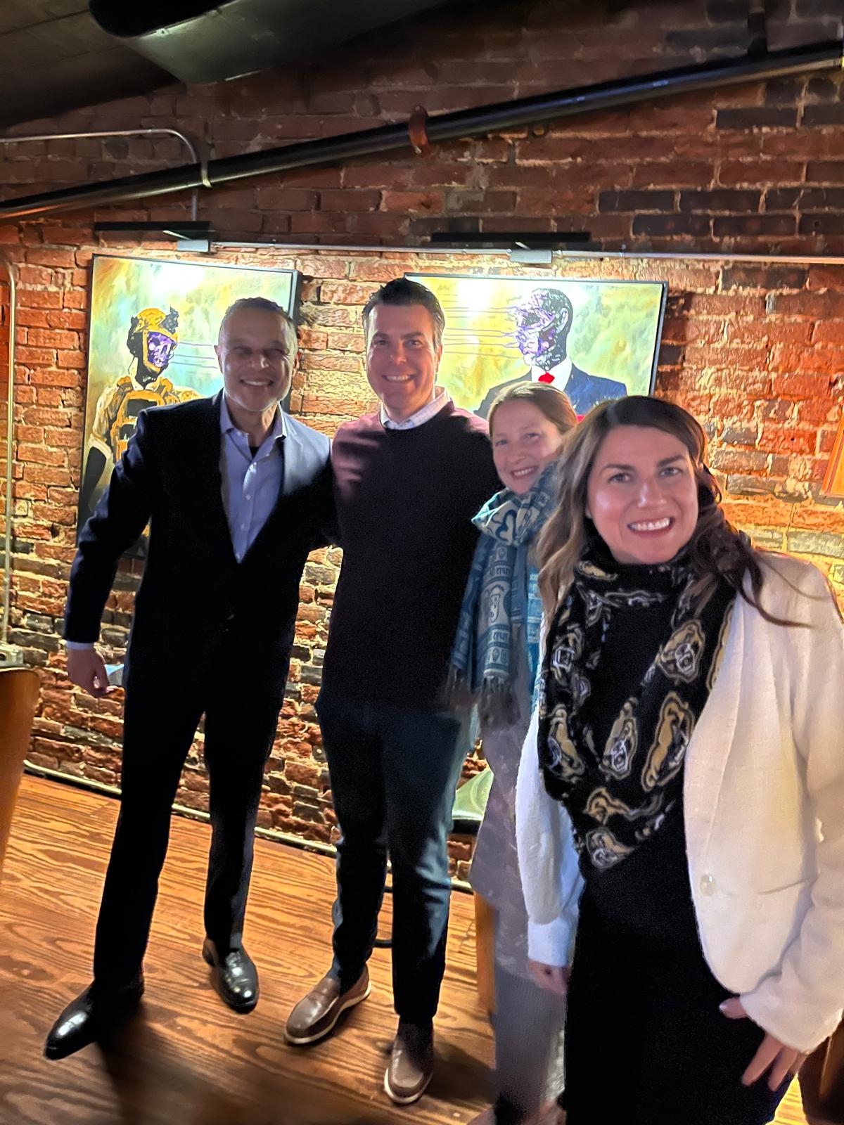Five people posing inside a bar
