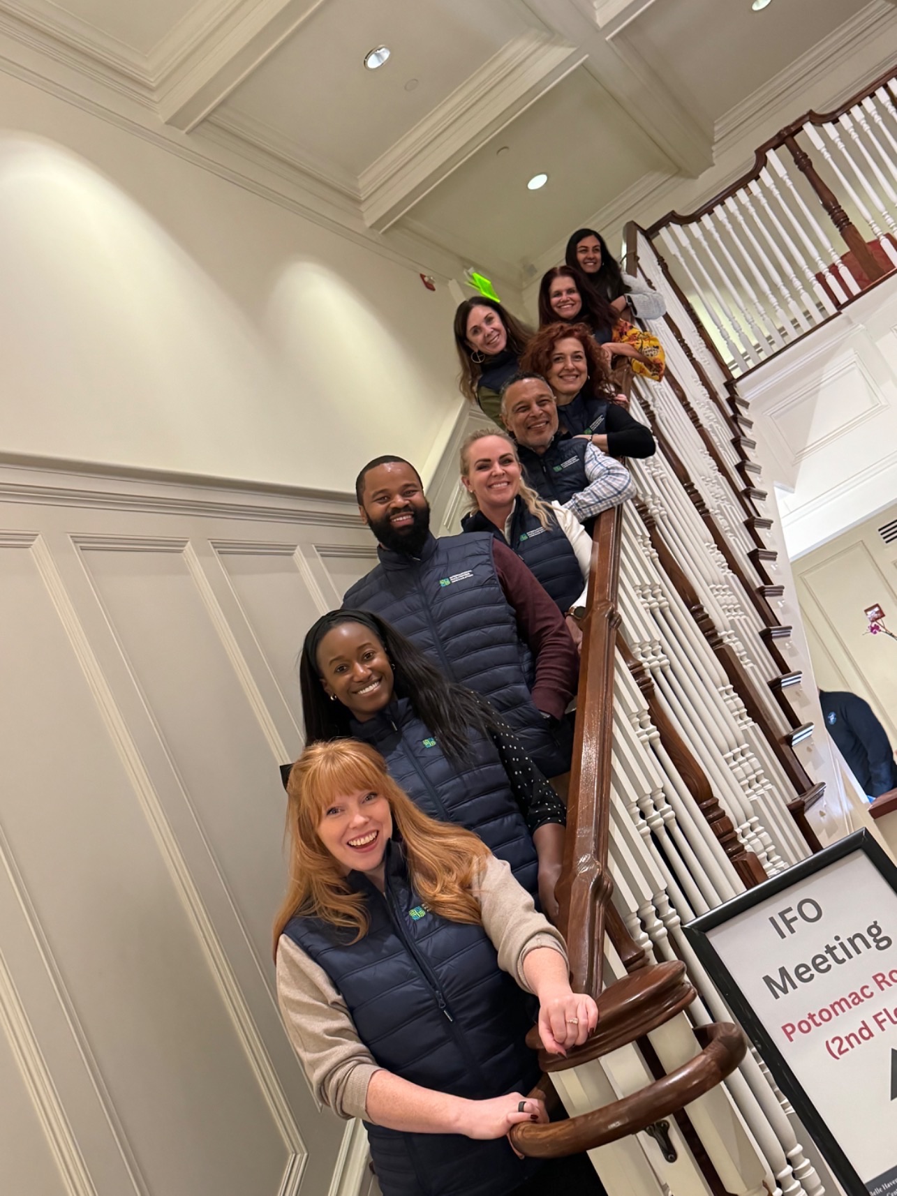 Smiling men and women on indoor stairs